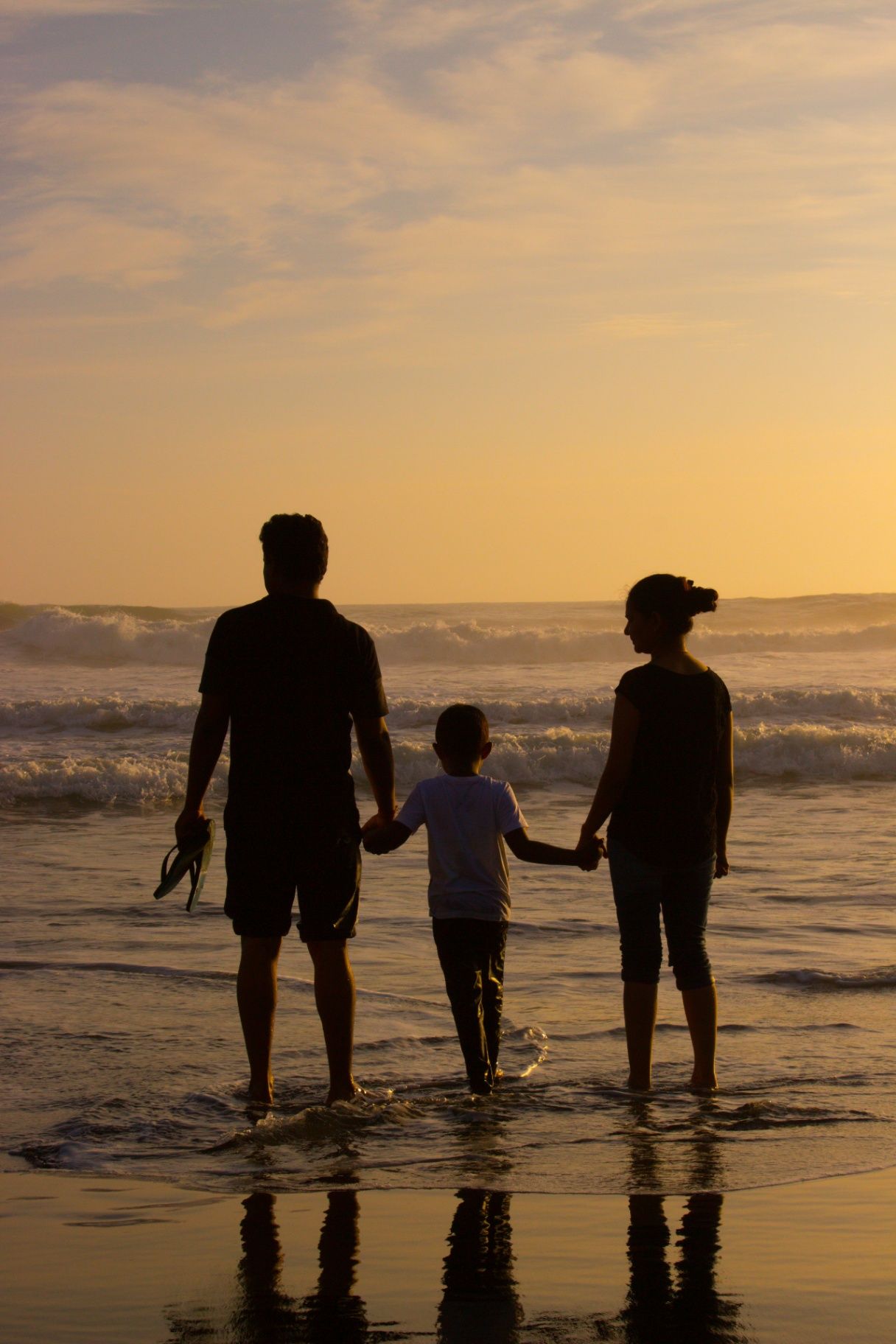 Family holding hands at sunset on a Zanzibar beach