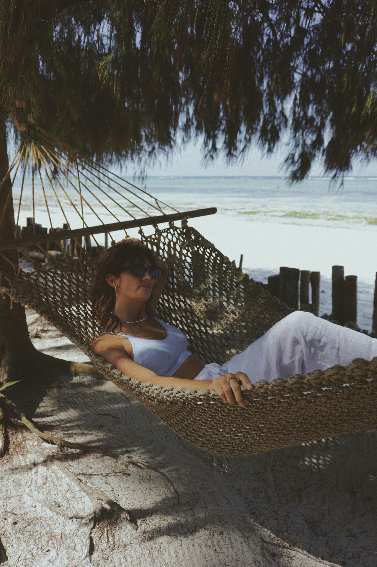 Traveler relaxing in a hammock by the beach in Zanzibar